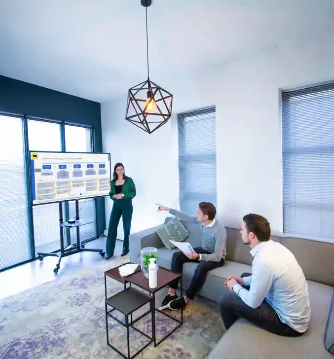 Drie Young Professionals bespreken verantwoordelijkheden op het kantoor van Young Consultant
